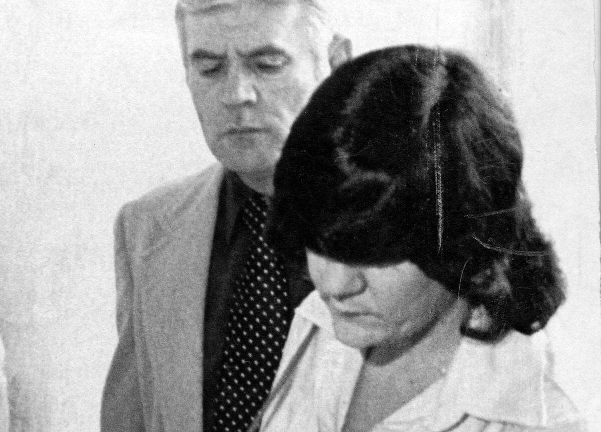 A 1979 file photo shows then U.S. Marshal Jimmy Britt (background) escorting Helena Stoeckley (right) into the U.S. District Courthouse in Raleigh after her arrest as a material witness in the triple murder trial of Dr. Jeffrey MacDonald.