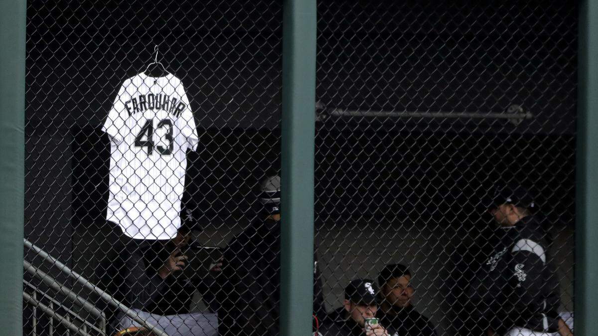 The jersey of White Sox relief pitcher Danny Farquhar hangs in front of the bullpen the game between the Astros and White Sox on Saturday. Farquhar was taken to the hospital after passing out in the dugout on Friday night.