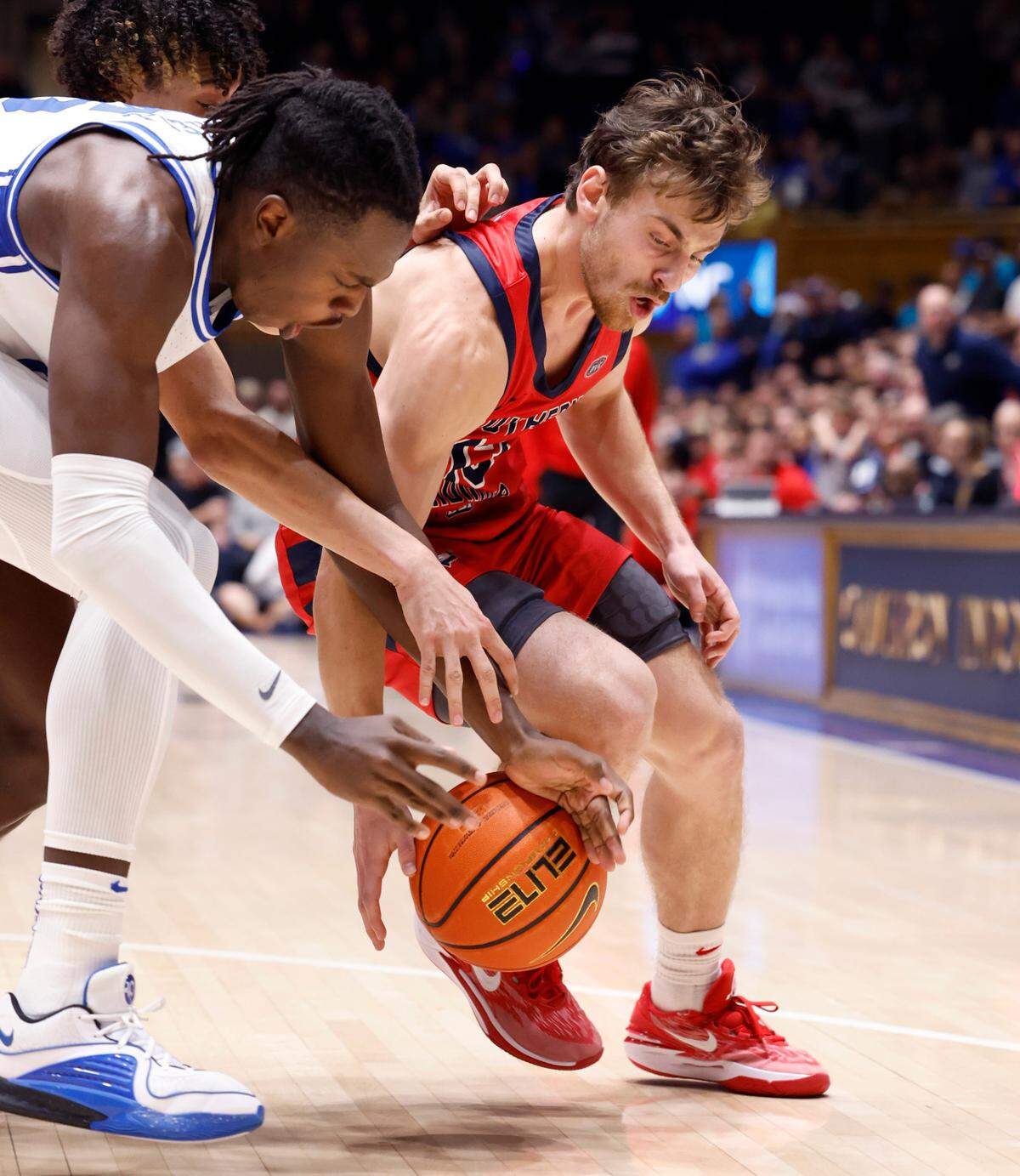 Southern Indiana’s Sam Mervis (13) gets the loose ball from Duke’s Mark Mitchell (25) during the second half of Duke’s 80-62 victory over Southern Indiana at Cameron Indoor Stadium in Durham, N.C., Friday, Nov. 24, 2023.