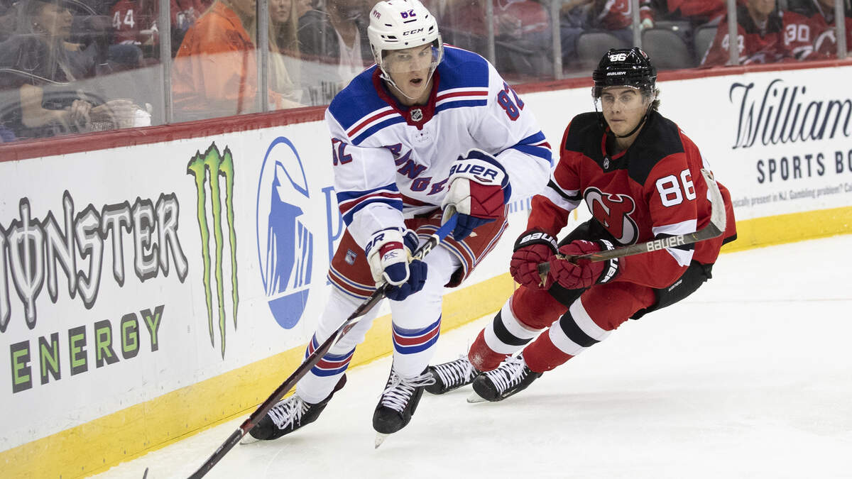 New York Rangers defenseman Joey Keane (82) controls the puck next to New Jersey Devils center Jack Hughes (86) during the second period of a preseason NHL hockey game Friday, Sept. 20, 2019, in Newark, N.J. (AP Photo/Mary Altaffer)