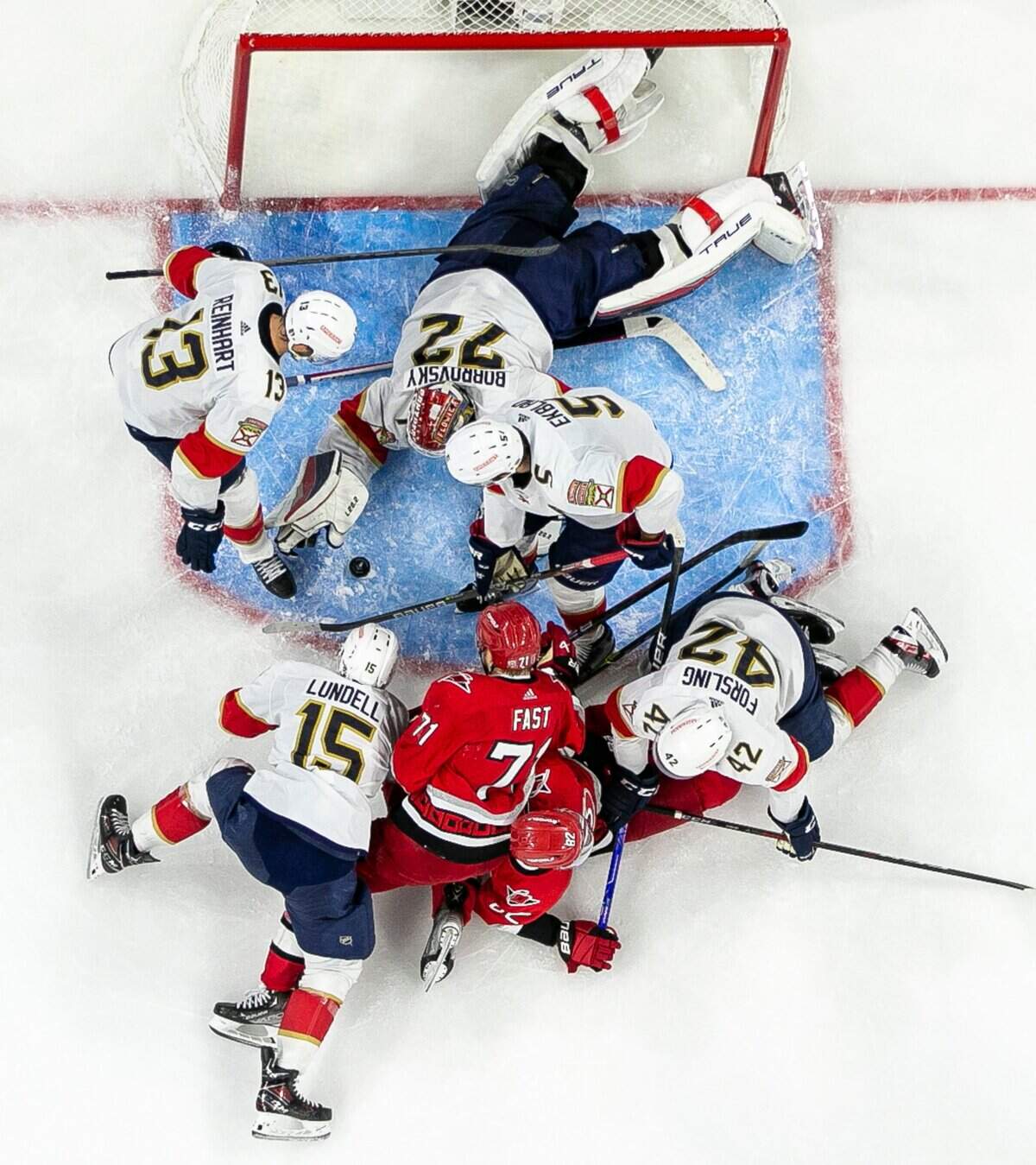 Florida Panthers goalie Sergei Bobrovsky (72) gets some help from Sam Reinhart (13) Aaron Ekblad (5) as they prevent the Carolina Hurricanes Jesper Fast (71) and Jesperi Kotkaniemi (82) from scoring in the first overtime period during Game 1 of the Eastern Conference Finals on Friday, May 19, 2023 at PNC Arena in Raleigh, N.C.