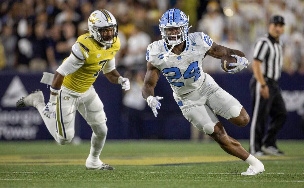 North Carolina’s British Brooks (24) looks for running room ahead of Georgia Tech’s Trenilyas Tatum (7) as he rushes for nine yards and a first down in the first quarter on Saturday, October 28, 2023 at Bobby Dodd Stadium in Atlanta, Georgia.