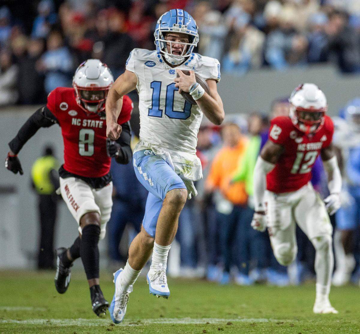 North Carolina quarterback Drake Maye (10) breaks open on a 56-yard gain ahead of N.C. State’s Robert Kennedy (8) and Devan Boykin (12) in the third quarter against N.C. State on Saturday, November 25, 2023 at Carter-Finley Stadium in Raleigh, N.C.