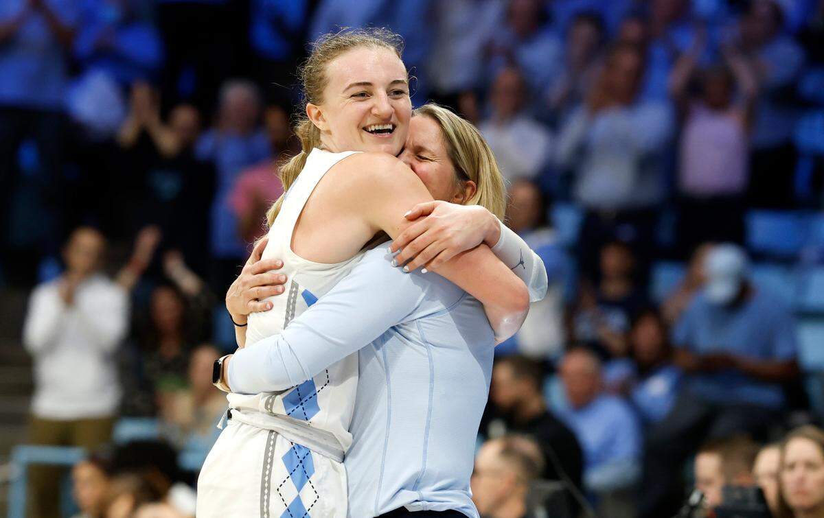 North Carolina’s Alyssa Ustby (1) hugs head coach Courtney Banghart in the final minute of UNC’s 58-47 victory over West Virginia in the second round of the NCAA women’s basketball tournament at Carmichael Arena in Chapel Hill, N.C., Monday, March 24, 2025.