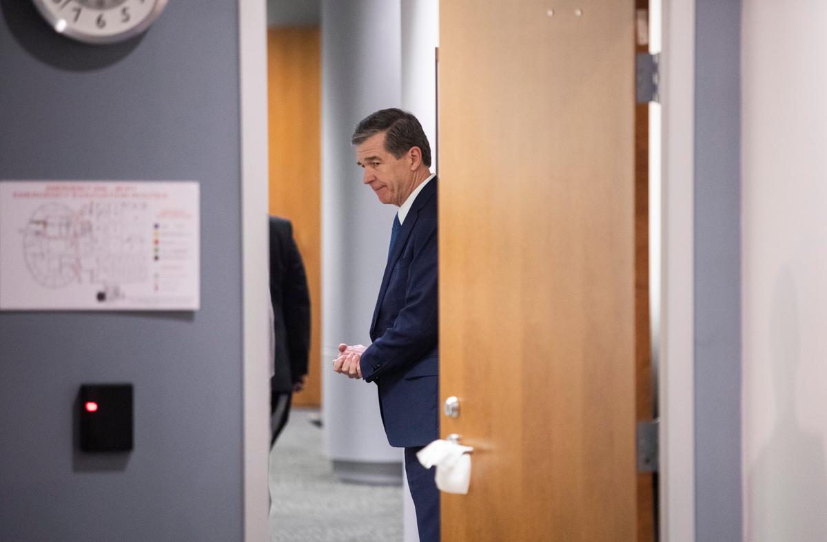 A sanitary wipe covers a door handle as Gov. Roy Cooper leaves a briefing on North Carolinas coronavirus pandemic response Friday, April 3, 2020 at the NC Emergency Operations Center in Raleigh.