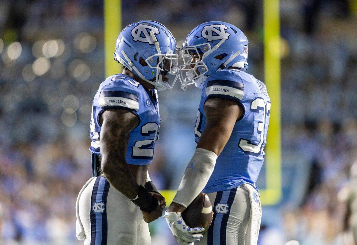 North Carolina’s Cedric Gray (33) and teammate Power Echols (23) celebrate Gray’s interception of Miami quarterback Tyler Van Dyke in the third quarter on Saturday, October 14, 2023 at Kenan Stadium in Chapel Hill, N.C.