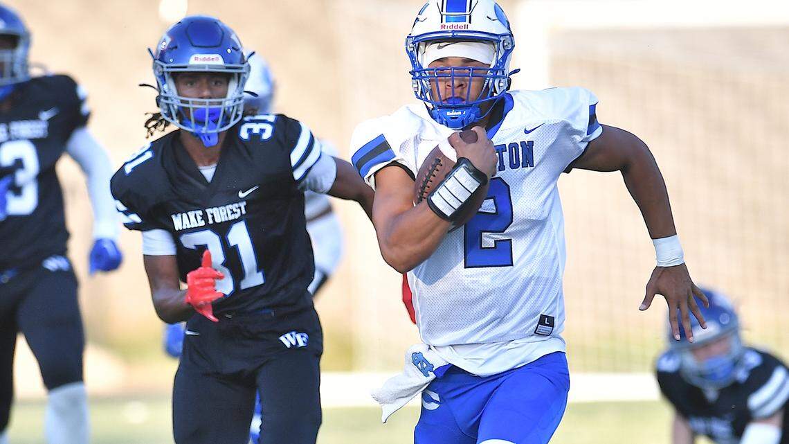 Clayton quarterback 	Aiden Smalls (2) rushes for yardage ahead of Wake Forest’s Nico Hunter (31) during the first half. The Wake Forest Cougars and the Clayton Comet met in a non-conference football game in Wake Forest, N.C. on August 23, 2024.