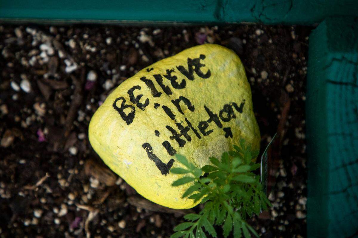 A rock painted with “Believe in Littleton” rests in a flower box on Main Street in Littleton, N.C., on Wednesday, July 28, 2021. Littleton has seen a return of retail businesses after investments by former resident Ed Fitts, and his wife Deb Fitts, who has returned in hopes of renewing his hometown through jobs, art and education