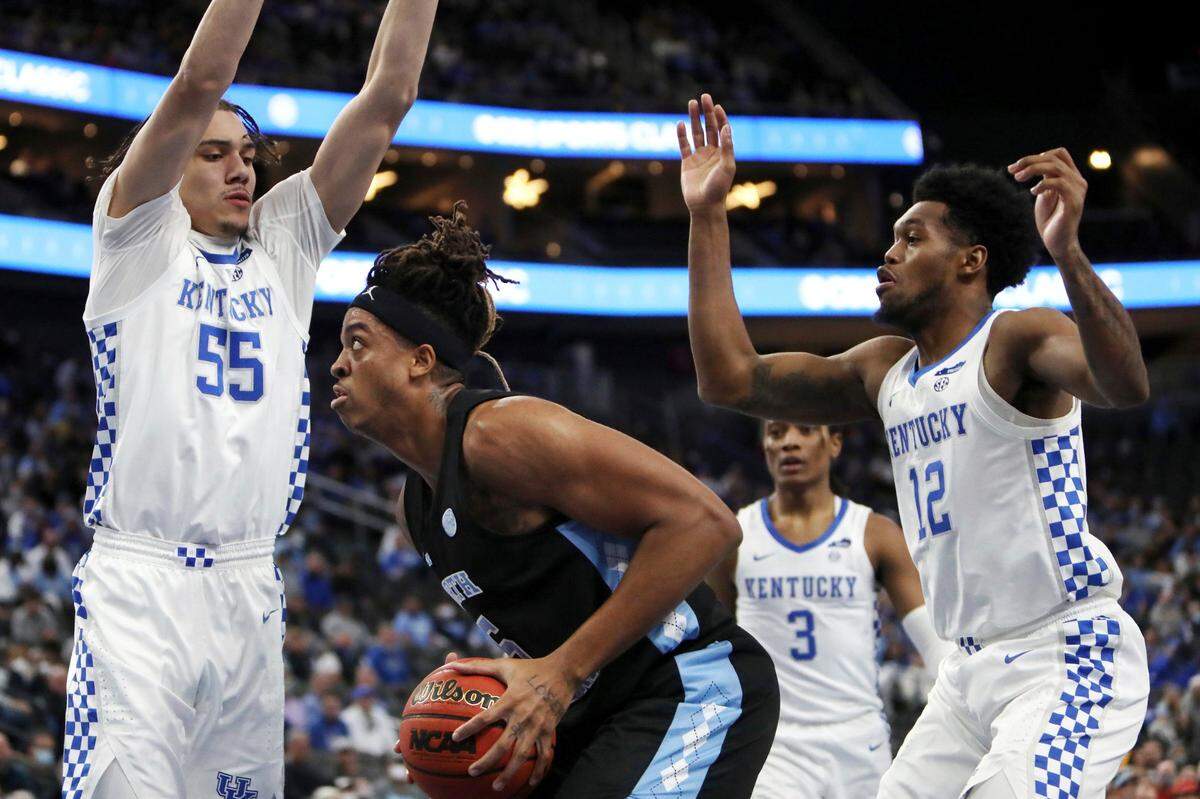 North Carolina’s Armando Bacot (5) goes for the rebound against Kentucky’s Lance Ware (55) and Keion Brooks Jr. (12) during the first half of an NCAA college basketball game Saturday, Dec. 18, 2021, in Las Vegas. (AP Photo/Joe Buglewicz)