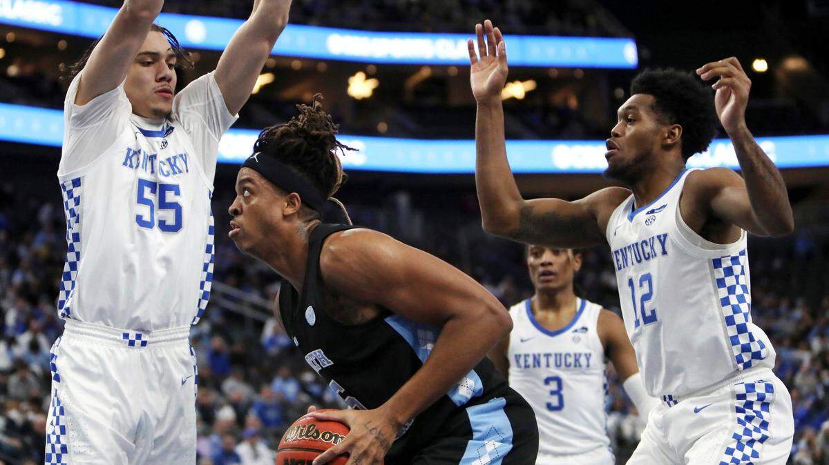 North Carolina’s Armando Bacot (5) goes for the rebound against Kentucky’s Lance Ware (55) and Keion Brooks Jr. (12) during the first half of an NCAA college basketball game Saturday, Dec. 18, 2021, in Las Vegas. (AP Photo/Joe Buglewicz)