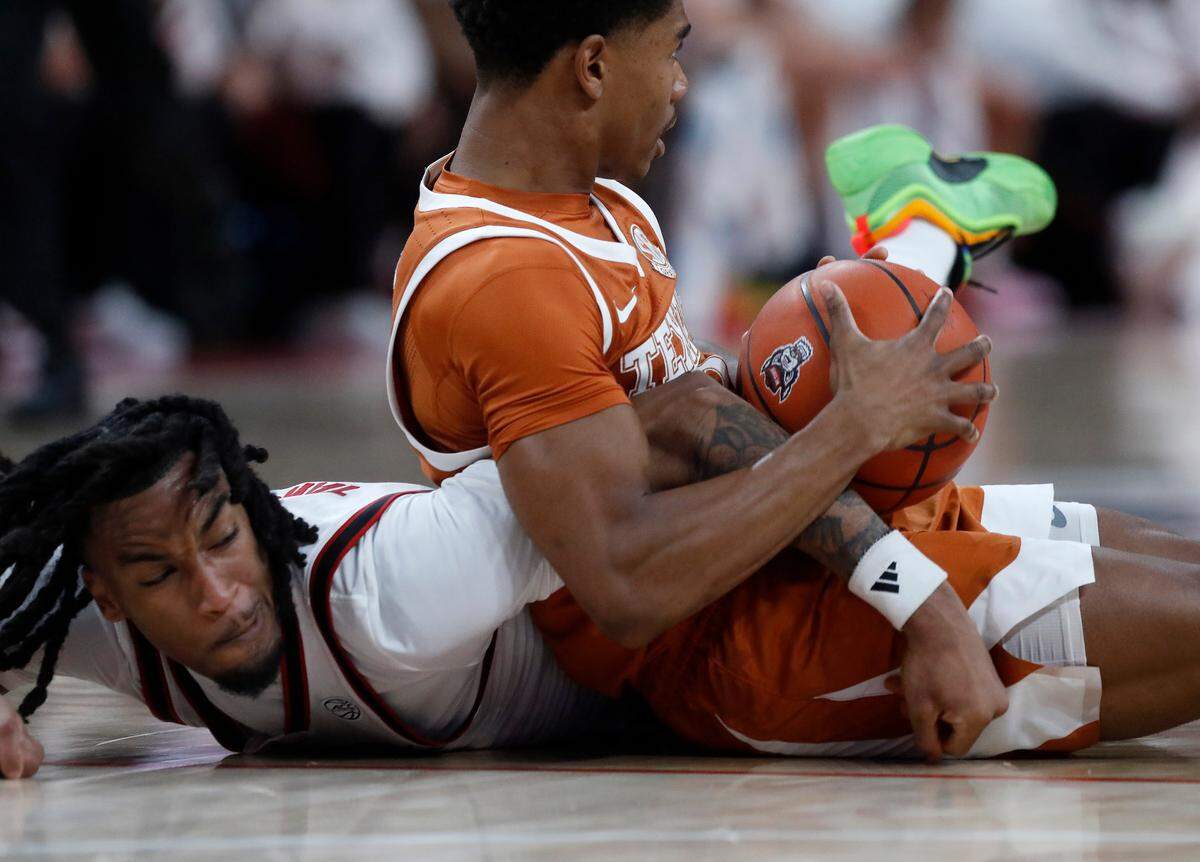 N.C. State’s Jayden Taylor and Texas’ Julian Larry scramble for a loose ball during the first half of the Wolfpack’s 63-59 loss on Wednesday, Dec. 4, 2024, at Lenovo Center in Raleigh, N.C.
