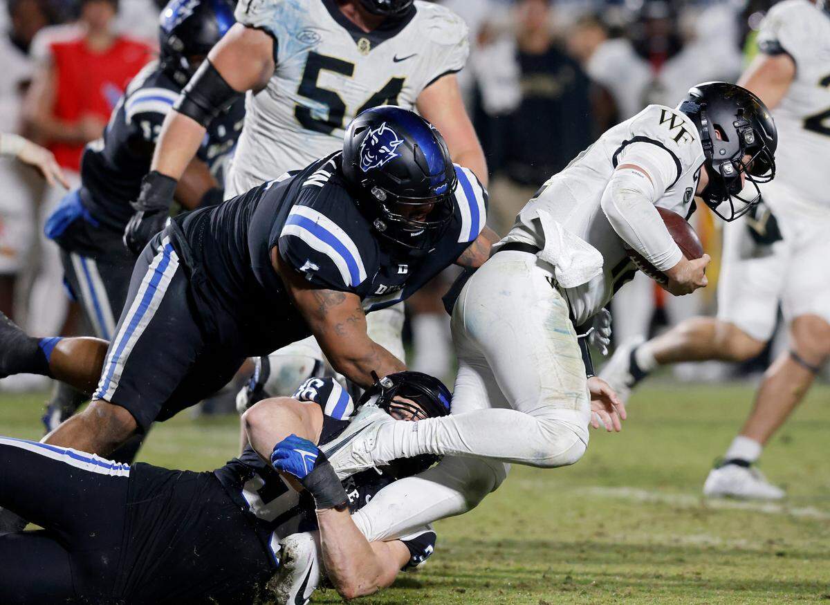 Wake Forest’s Mitch Griffis is brought down by Duke’s Nick Morris Jr. and Ja’Mion Franklin during the second half of the Blue Devils’ 24-21 win on Thursday, Nov. 2, 2023, at Wallace Wade Stadium in Durham, N.C.