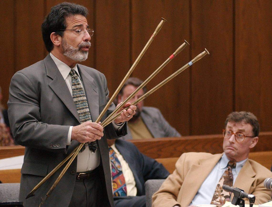 Defense attorney David Rudolf holds three fireplace blow pokers as he questions Durham Police Detective Art Holland during the Michael Peterson murder trial on Monday, Sept. 29, 2003. Peterson, right, was on trial for the murder his wife, Kathleen Peterson, who was found dead at the bottom of a staircase in the Peterson's home on Dec. 9, 2001.