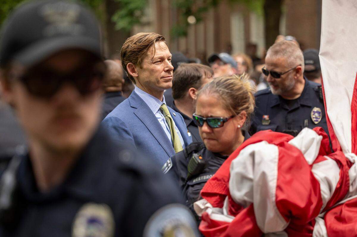 Interim Chancellor Lee Roberts and police officers work to rehang an American flag after it was brought down by demonstrators and replaced with a Palestinian flag in April 30 at UNC-Chapel Hill.