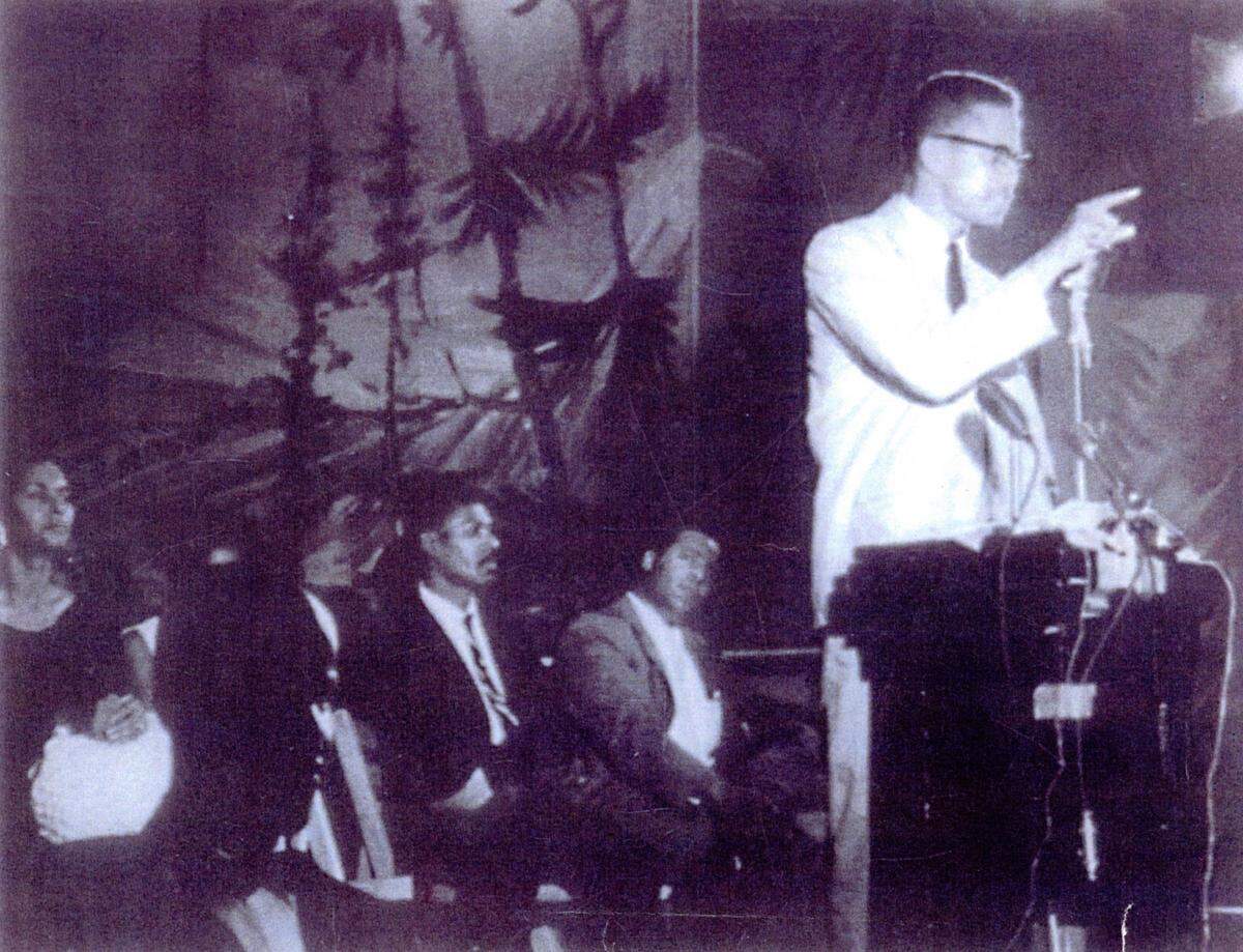 Ora Mobley Sweeting (far left) sits on stage as Malcolm X presents the formation of the Organization of Afro-American Unity in 1964.