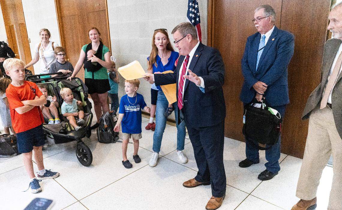 House Speaker Tim Moore accepts a letter signed by parents that urged Republican lawmakers to keep their promise to fully fund private school vouchers for the 55,000 students on the Opportunity Scholarship waiting list on Wednesday, July 31, 2024 at the Legislative Building.
