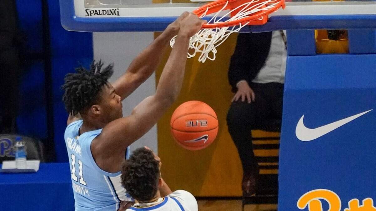 North Carolina’s Day’Ron Sharpe (11) dunks in front of Pittsburgh’s Terrell Brown during the first half of an NCAA college basketball game Tuesday, Jan. 26, 2021, in Pittsburgh.