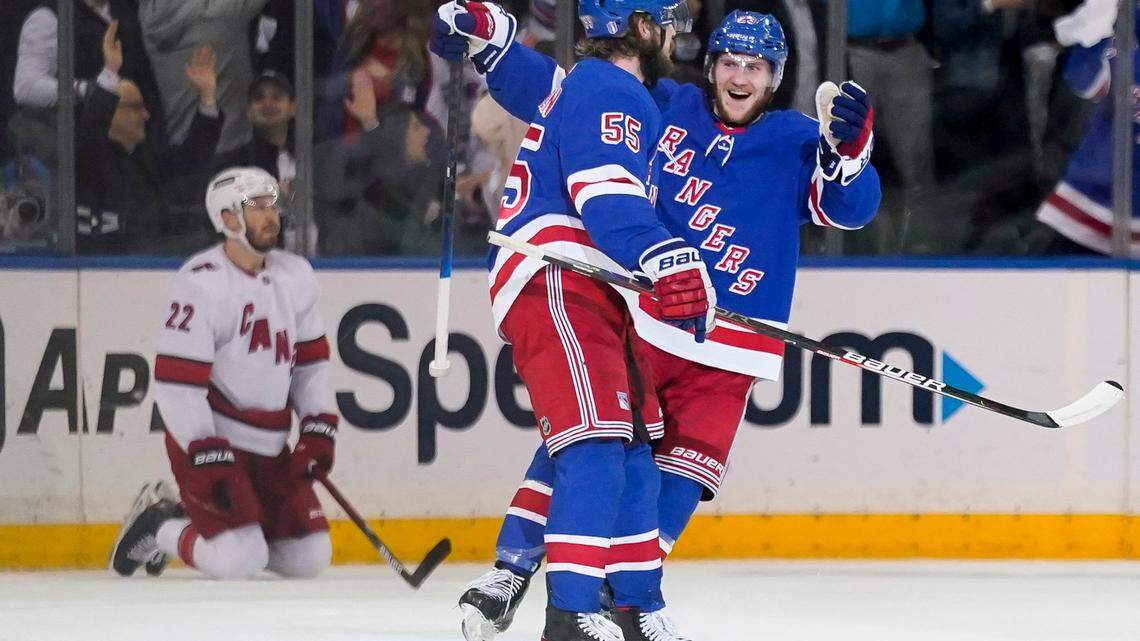 New York Rangers defenseman Adam Fox, right, celebrates with defenseman Ryan Lindgren (55) after scoring on Carolina Hurricanes goaltender Antti Raanta in the first period of Game 4 of an NHL hockey Stanley Cup second-round playoff series, Tuesday, May 24, 2022, in New York. (AP Photo/John Minchillo)