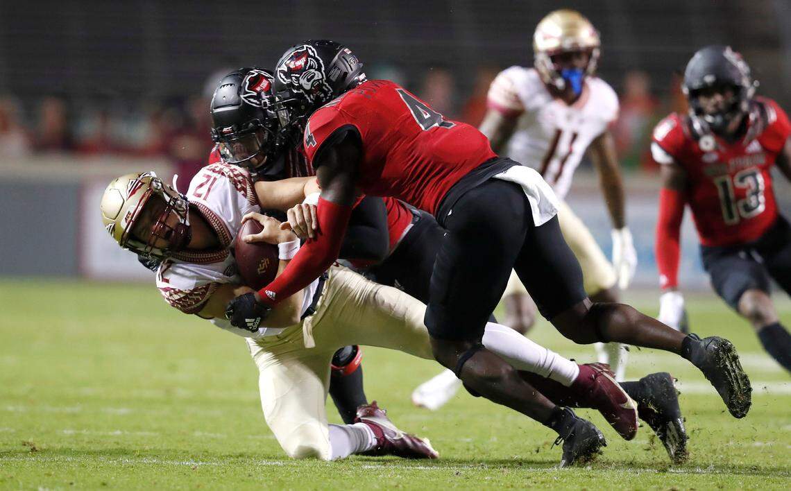 N.C. State linebacker Isaiah Moore (1) and cornerback Cecil Powell (4) tackle Florida State quarterback Chubba Purdy (12) during the first half of N.C. State’s game against Florida State at Carter-Finley Stadium in Raleigh, N.C., Saturday, Nov. 14, 2020.