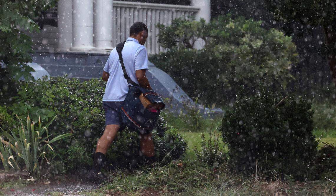 A postman delivers the mail as heavy rain falls in Raleigh, N.C. Tuesday, August 15, 2023.
