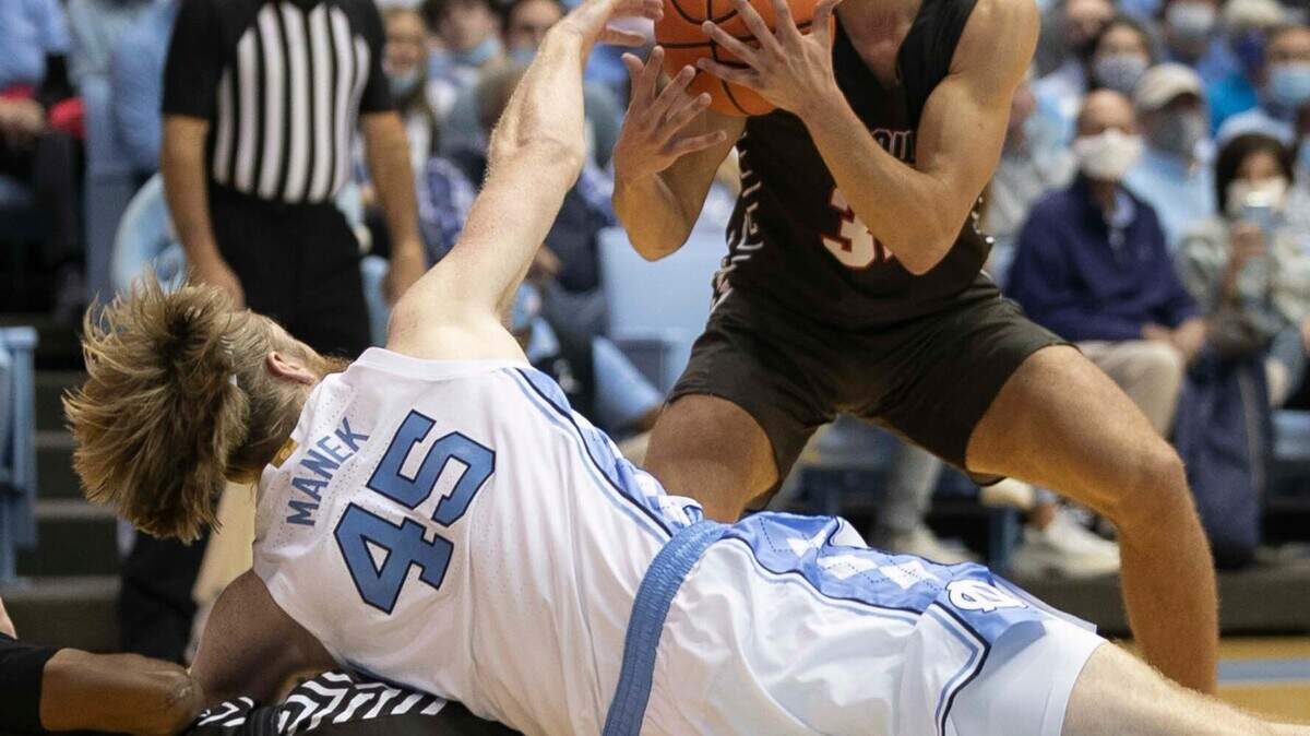 North Carolina’s Brady Manek (45) turns the ball over to Brown’s Paxson Wojcik (32)) during the first half on Friday, November 12, 2021 at the Smith Center in Chapel Hill, N.C.