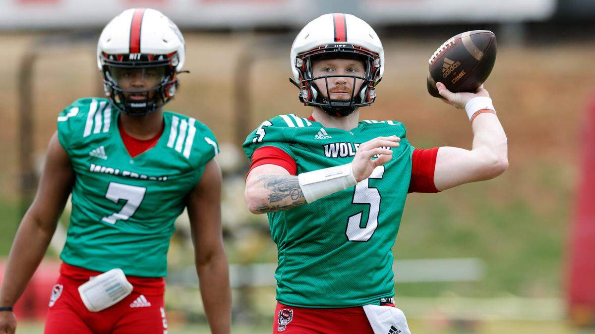 N.C. State quarterback Brennan Armstrong (5) throws as N.C. State quarterback MJ Morris (7) watches during the Wolfpack’s first spring practice in Raleigh, N.C., Wednesday, March 1, 2023.
