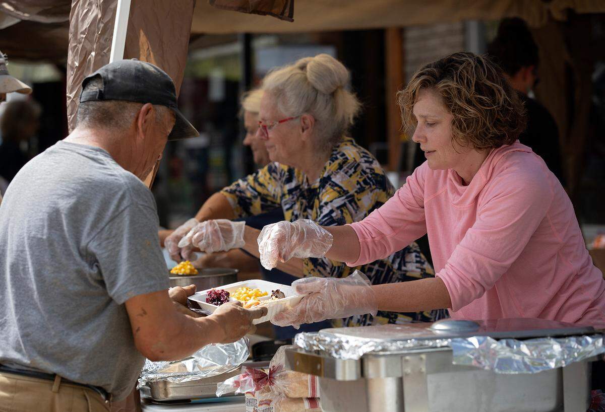 Summer Crosby, right, serves lunch outside of Spear Country Store & Hardware on Thursday, Oct. 3, 2024, in Newland, N.C., days after Hurricane Helene brought heavy flooding to the region.