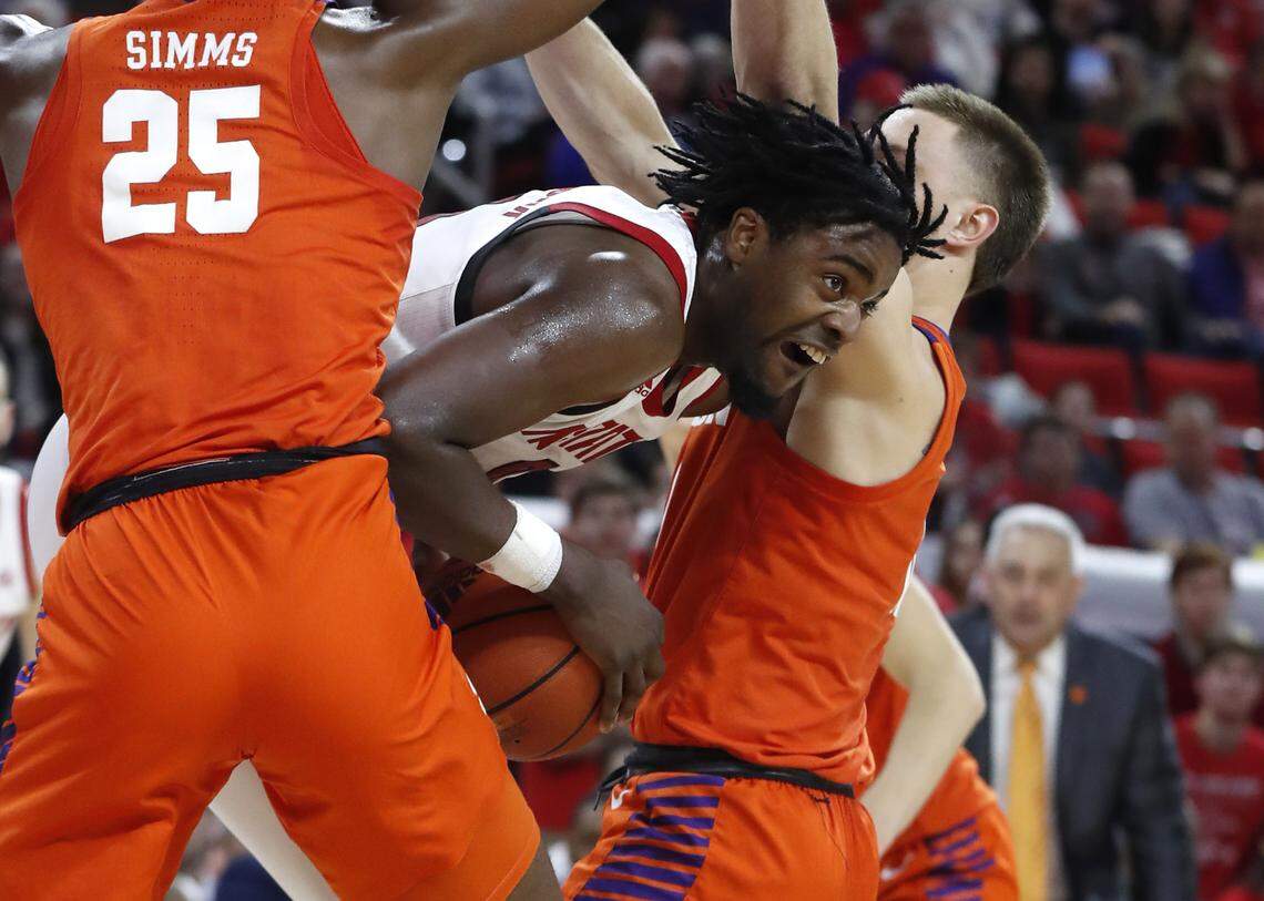 N.C. State’s D.J. Funderburk (0) looks for room between Clemson’s Aamir Simms (25), left, and Curran Scott (10) during the first half of N.C. State’s game against Clemson at PNC Arena in Raleigh, N.C., Saturday, Jan. 18, 2020.