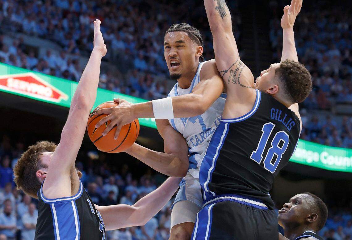 North Carolina’s Seth Trimble (7) drives between Duke’s Mason Gillis (18) and Kon Knueppel (7) during the first half of Duke’s game against UNC at the Smith Center in Chapel Hill, N.C., Saturday, March 8, 2025.