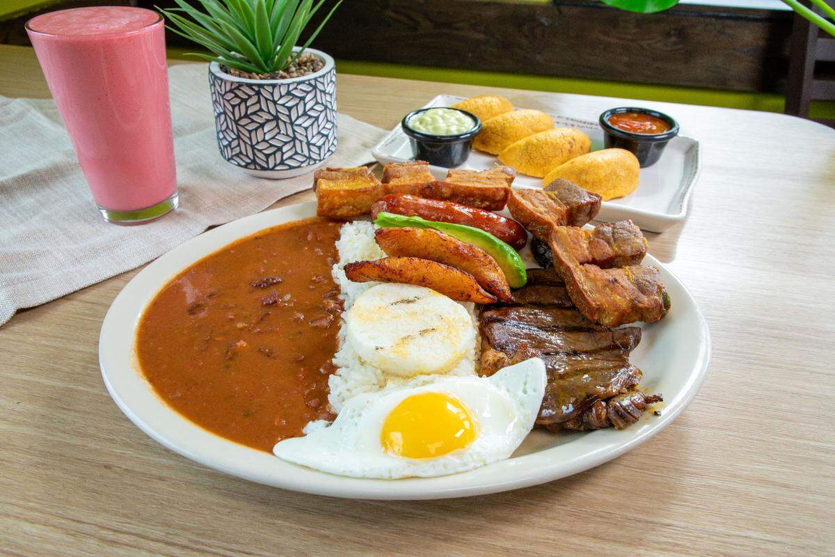 Served at Cali Colombian Restaurant, bandeja paisa comes with grilled steak, fried pork rind, sausage, rice, beans, arepa, sweet plantains, egg and avocado.