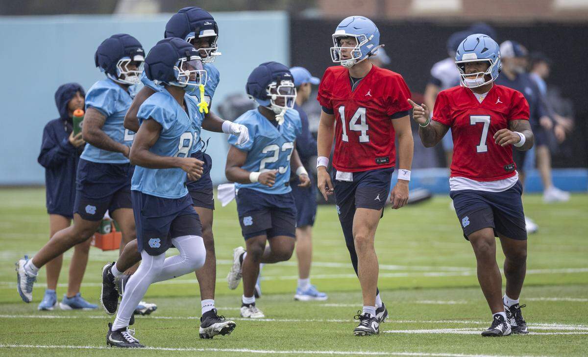 North Carolina quarterbacks Max Johnson (14) and Gio Lopez (7) direct teammates to their next drill station during the Tar Heels’ practice on Saturday, August 2, 2025 in Chapel Hill, N.C.