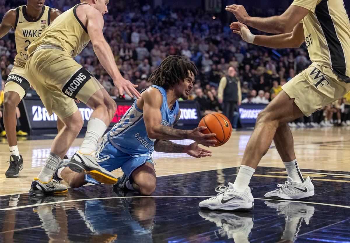 North Carolina guard Elliot Cadeau (3) looses the ball in the lane under defensive pressure from Wake Forest’s Cameron Hildreth (6) and Efton Reid III (4) in the second half on Tuesday, January 21, 2025 at Lawrence Joel Coliseum in Winston-Salem, N.C.