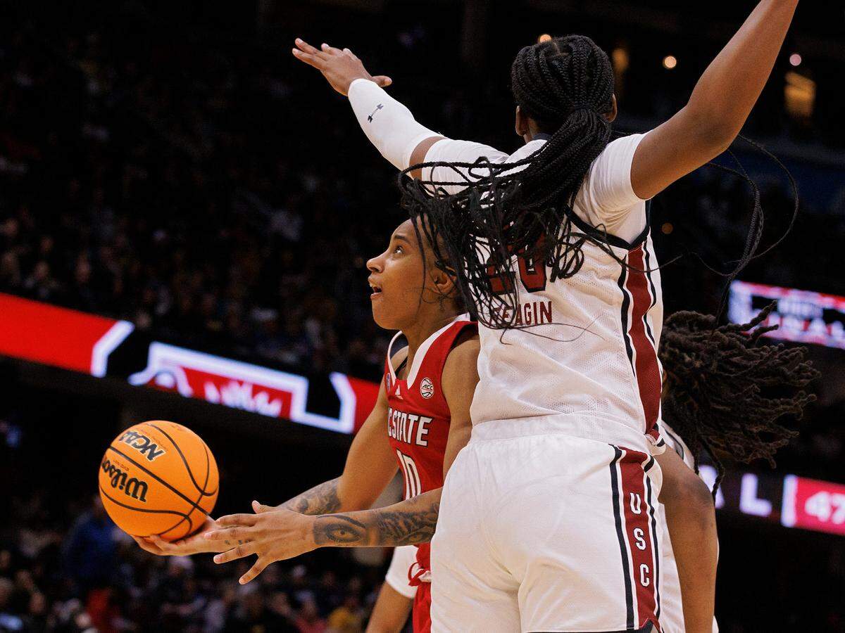 N.C. State’s Aziaha James is fouled while driving past South Carolina’s Sania Feagin during the second half of the Wolfpack’s 78-59 Final Four loss at Rocket Mortgage FieldHouse on Friday, April 5, 2024, in Cleveland, Ohio.