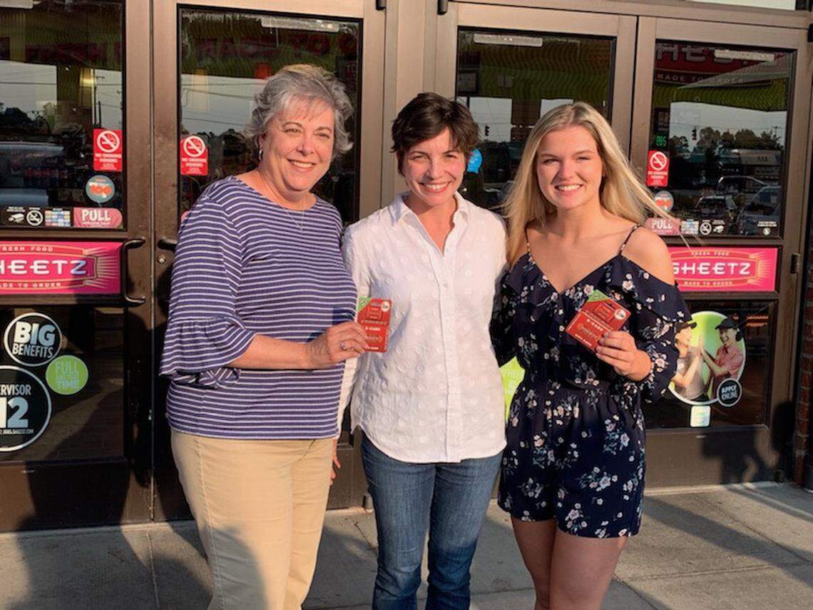 Sherry Allgood, Emily Sheetz and Devin Bennett pose Monday at a gas station, where Sheetz says a chance encounter occurred.