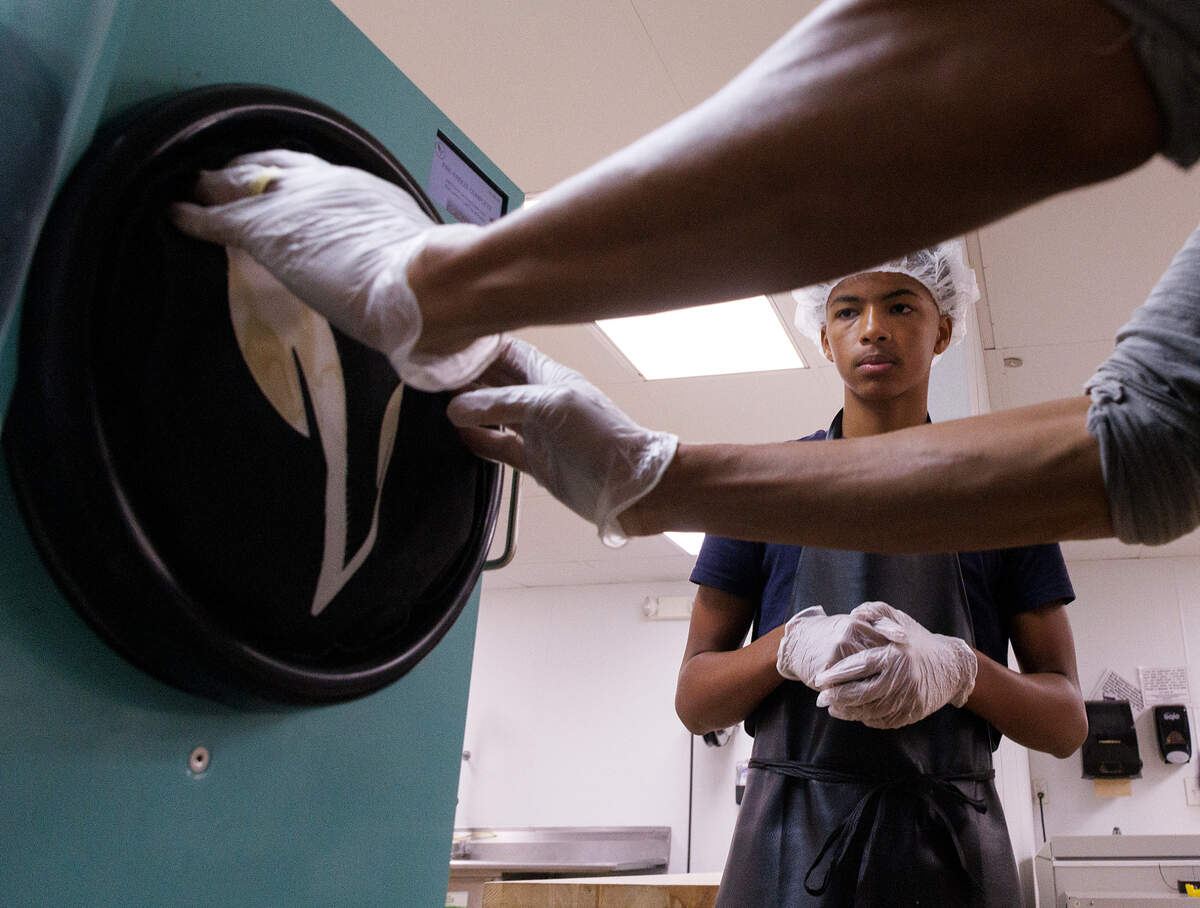 Justice Freelon, 15, watches as his dad, Pierce Freelon, prepares freeze-dried ice cream at Piedmont Food Processing Center in Hillsborough, N.C. on Tuesday, June 4, 2024.
