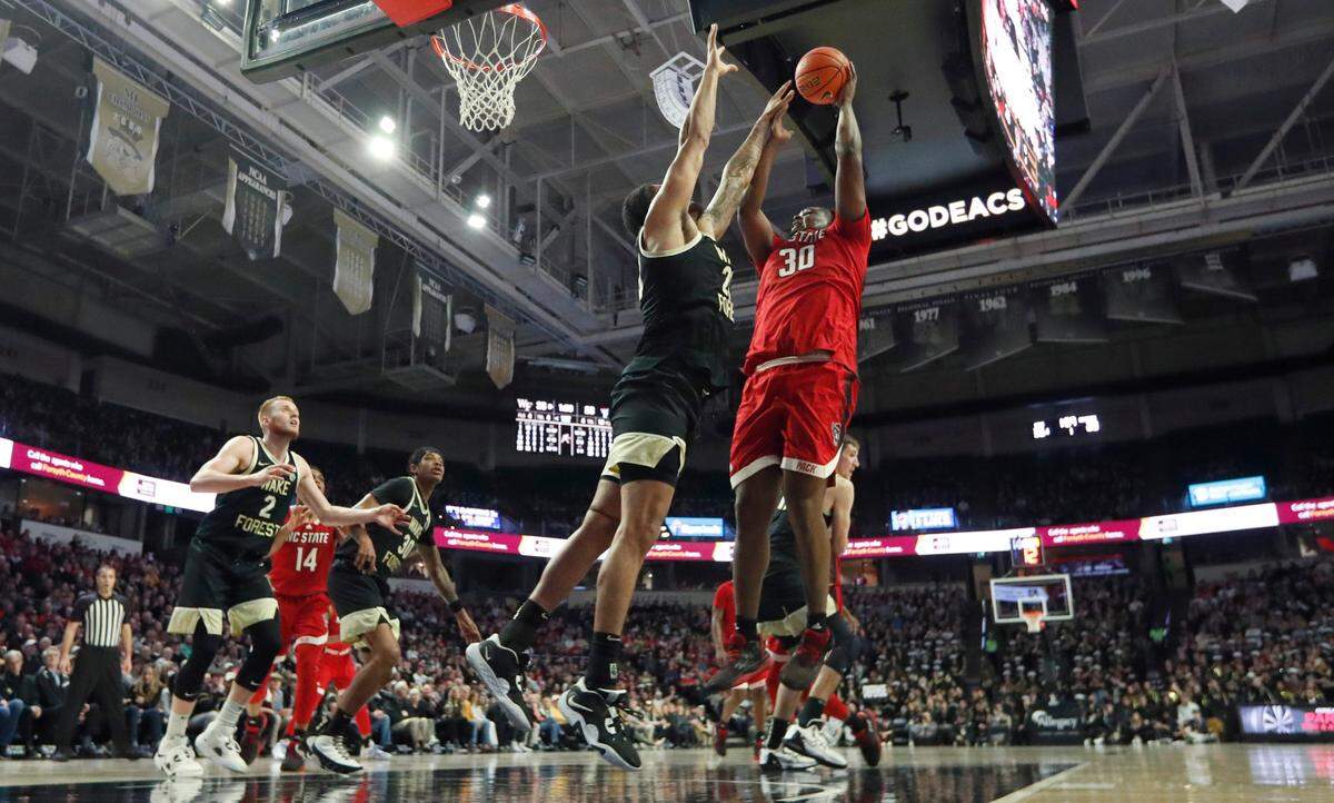 N.C. State’s D.J. Burns Jr. (30) shoots as Wake Forest’s Davion Bradford (20) defends during N.C. State’s 79-77 victory over Wake Forest at Joel Coliseum in Winston-Salem, N.C., Saturday, Jan. 28, 2023.
