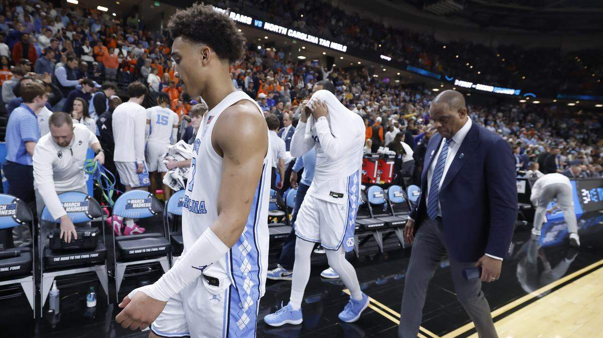 North Carolina's Seth Trimble (7), Isaiah Denis (5) and head coach Hubert Davis walk off the court after VCU’s 82-78 overtime victory over UNC in the first round of the NCAA Men’s Basketball Tournament at  Bon Secours Wellness Arena in Greenville, S.C., Thursday, March 19, 2026.