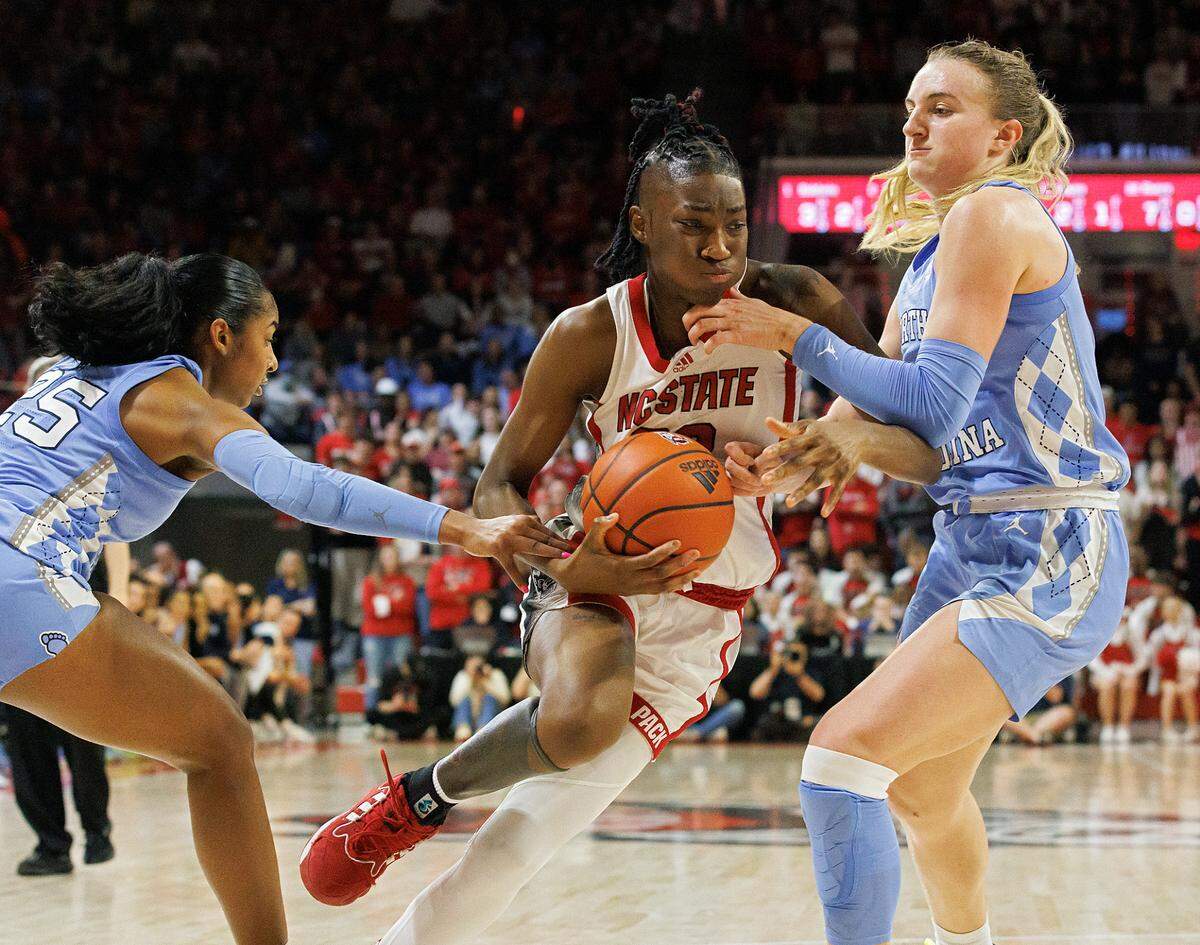 N.C. State’s Saniya Rivers splits the defense of North Carolina’s Deja Kelly and Alyssa Ustby during the second half of the Wolfpack’s 63-59 win on Thursday, Feb. 1, 2024, at Reynolds Coliseum in Raleigh, N.C.