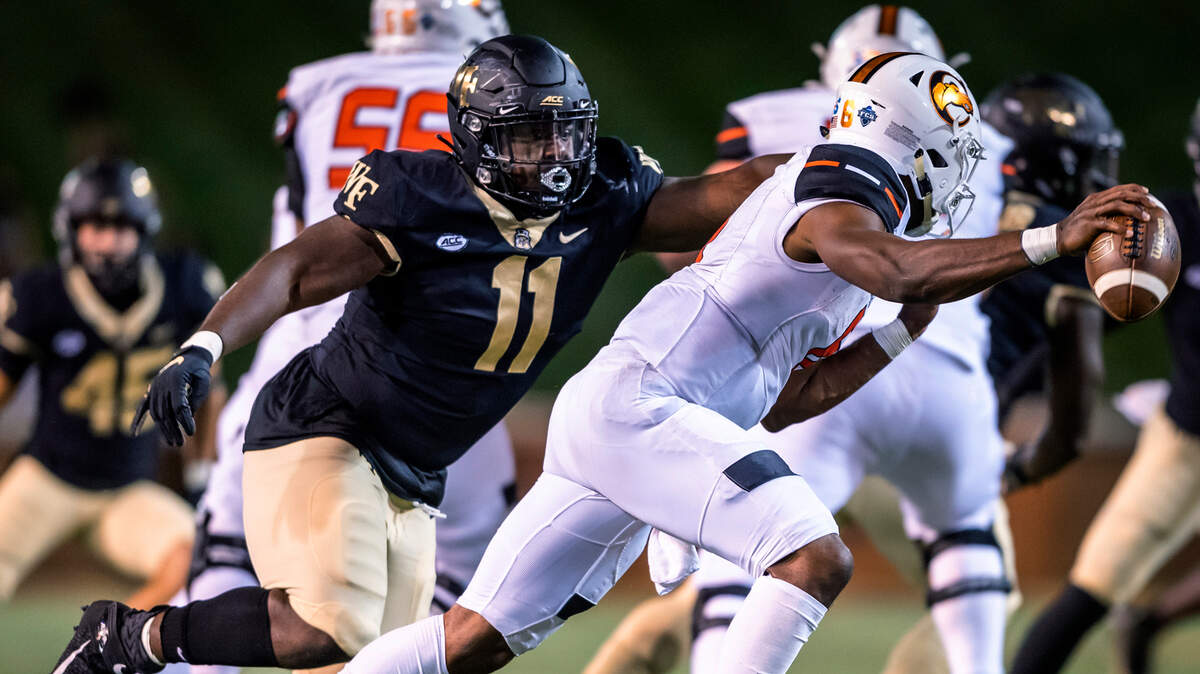 Campbell quarterback Hajj-Malik Williams scrambles under pressure from Wake Forest defensive lineman Miles Fox (11) during an NCAA college football game Friday, Oct. 2, 2020, in Winston-Salem, N.C. (Andrew Dye/The Winston-Salem Journal via AP)