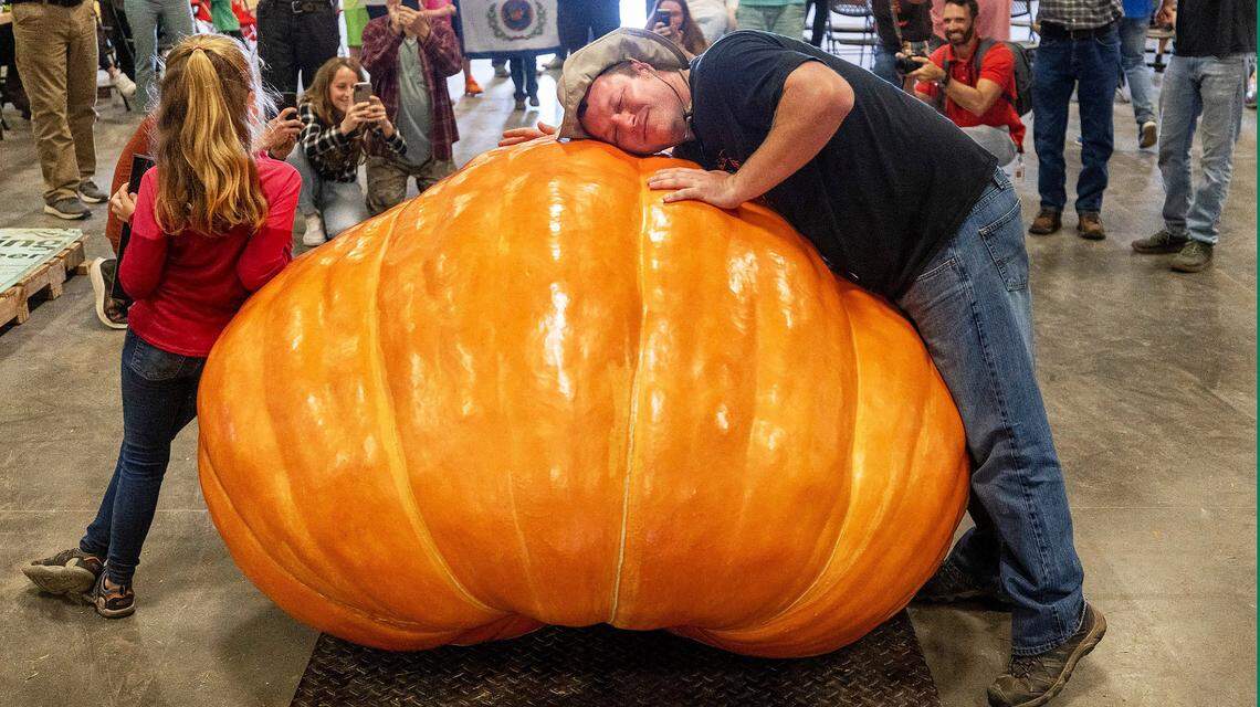 Chris Rodebaugh of Lewisburg, West Virginia, embraces his prize winning pumpkin, which weighed in at 1461 pounds, following the weigh-off for the giant pumpkin contest on Tuesday, October 11, 2022 at the Expo Center for the 2022 N.C. State Fair in Raleigh, N.C.