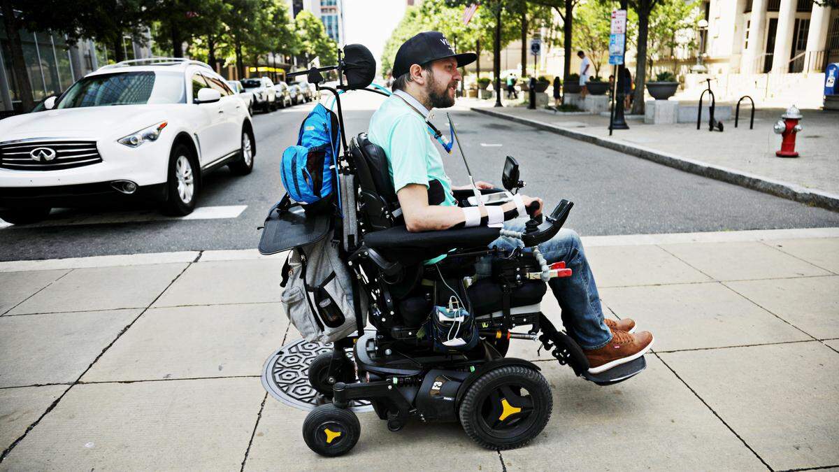 Michael Thor navigates the downtown Raleigh sidewalks by himself with his powered wheelchair to get to his restaurant, Whiskey Kitchen, nearby on July 1, 2019. Thor is starting to regain some independence after a motorcycle accident four years ago left him with a serious spinal cord injury and quadriplegia.