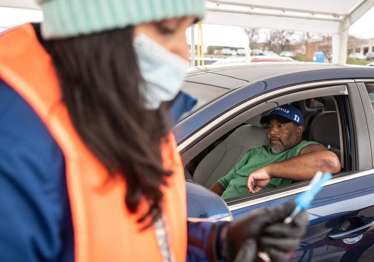 Ann Mathew (left) prepares a COVID-19 vaccine for Christopher Hartsoe in Salisbury, NC, on Wednesday, March 17, 2021.