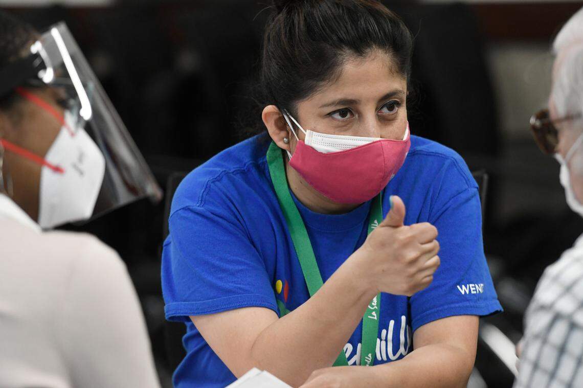 Wendy Tenorio, one of La Semilla’s community health workers, talks with as man before he receives a COVID vaccination at a pop-up clinic in Garner targeting members of the Hispanic population Saturday, March 13, 2021.