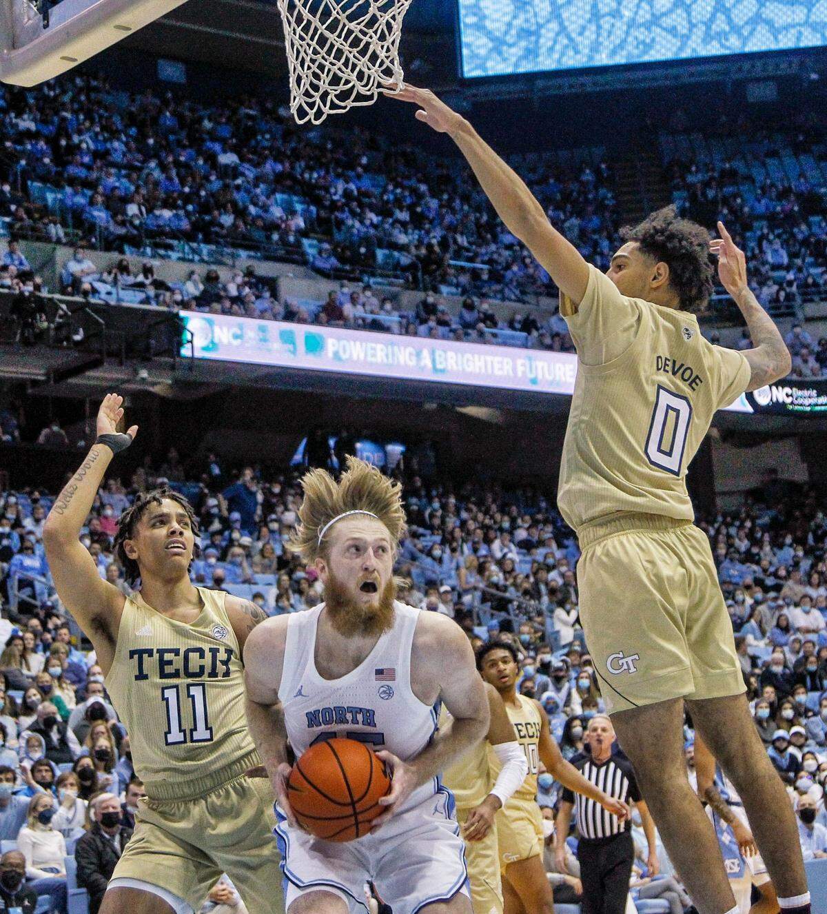 UNC’s Brady Manek (45) pulls down a rebound against Georgia Tech’s Tristan Maxwell (11) and Michael Devoe (0) during the first half Saturday, Jan. 15, 2022 at the Smith Center in Chapel Hill, N.C.