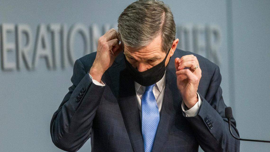 Gov. Roy Cooper removes his mask before speaking during a briefing on North Carolina’s coronavirus pandemic response Tuesday, Jan. 12, 2021, at the NC Emergency Operations Center in Raleigh.