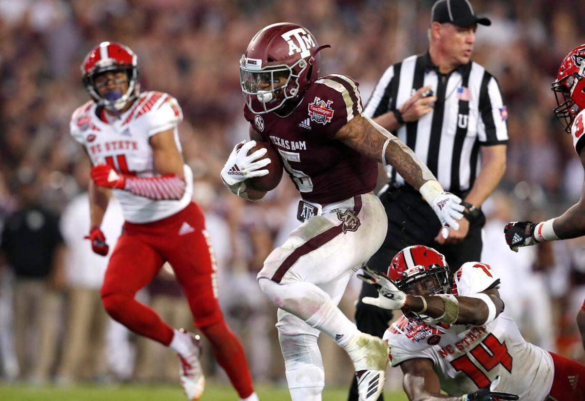 Texas A&M running back Trayveon Williams (5) scores on a 17-yard touchdown run as he runs past N.C. State safety Dexter Wright (14) during the second half of Texas A&M’s 52-13 victory over N.C. State in the TaxSlayer Gator Bowl at TIAA Bank Field in Jacksonville, Fla., Monday, Dec. 31, 2018.