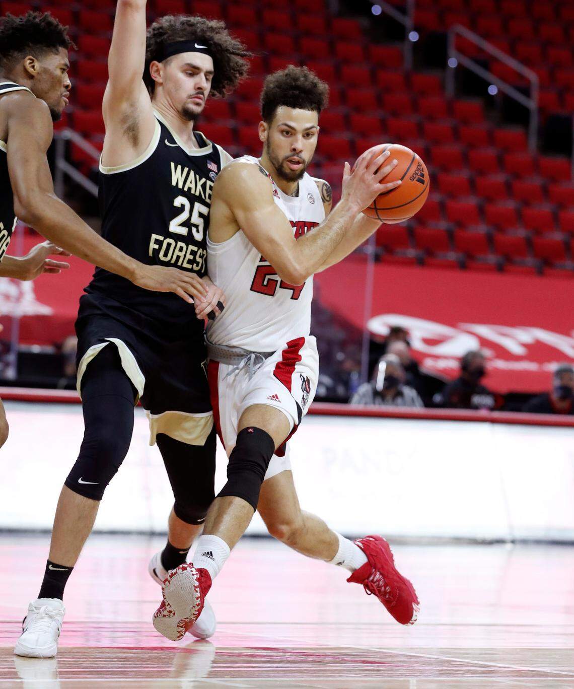 N.C. State’s Devon Daniels (24) drives past Wake Forest’s Ismael Massoud (25) during the first half of N.C. State’s game against Wake Forest at PNC Arena in Raleigh, N.C., Wednesday, January 27, 2021.