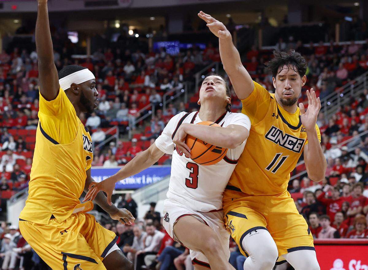 N.C. State’s Matt Able drives to the basket past UNC Greensboro’s Valentino Pinedo during the first half of the Wolfpack’s 110-64 win on Wednesday, Nov. 12, 2025, at Lenovo Center in Raleigh, N.C.