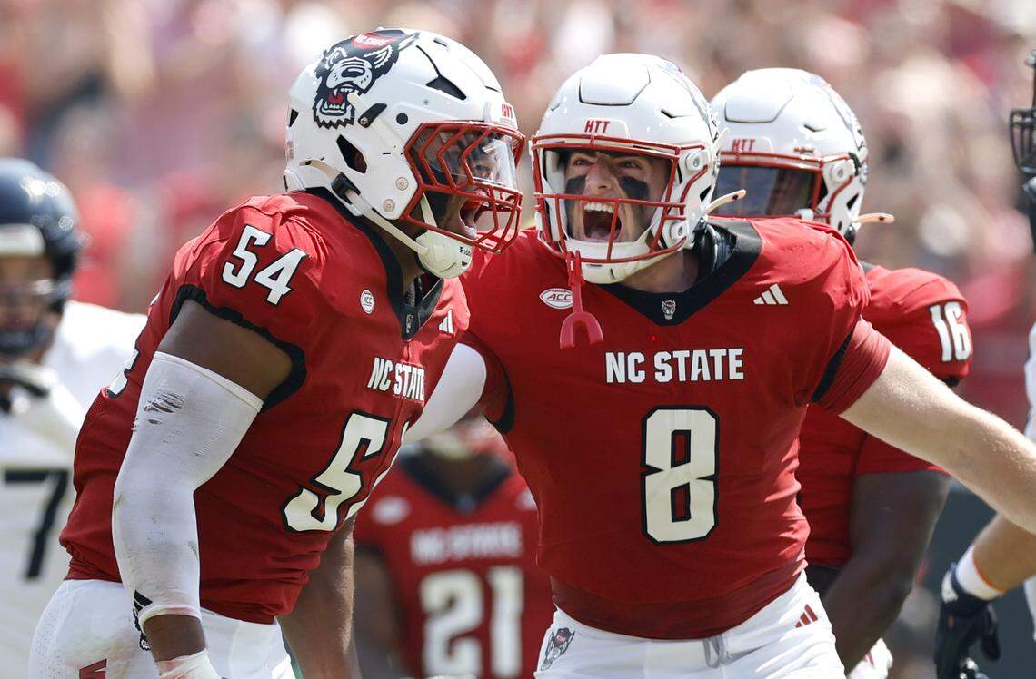 N.C. StateÕs Cian Slone (8) celebrates with Sabastian Harsh (54) after Harsh stopped Virginia for a loss during the first half of N.C. StateÕs game against Virginia at Carter-Finley Stadium in Raleigh, N.C., Sat. Sept. 6, 2025.