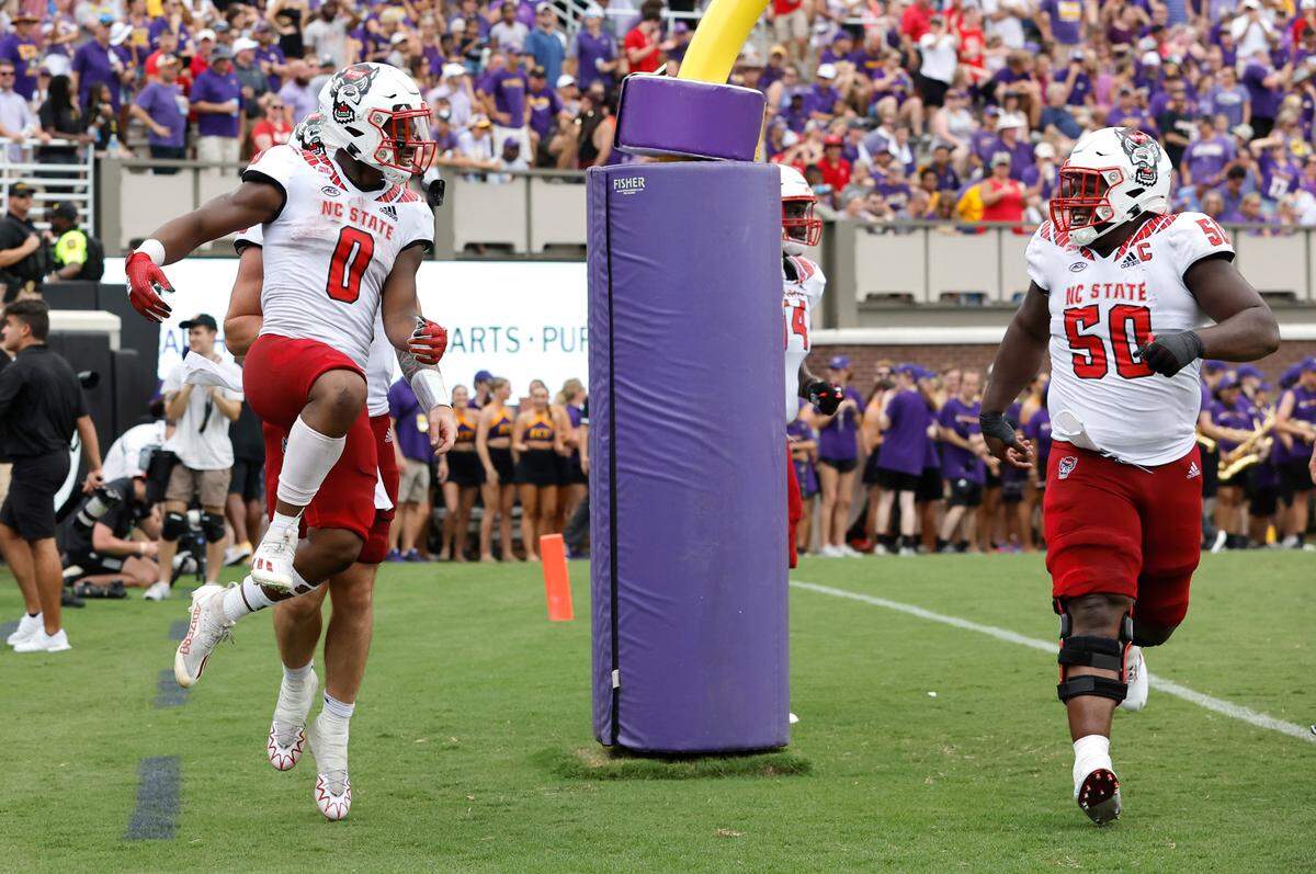 N.C. State running back Demie Sumo-Karngbaye (0) celebrates with center Grant Gibson (50) after Sumo-Karngbaye scored on a 24-yard touchdown run during the first half of N.C. State’s game against ECU at Dowdy-Ficklen Stadium in Greenville, N.C., Saturday, Sept. 3, 2022.